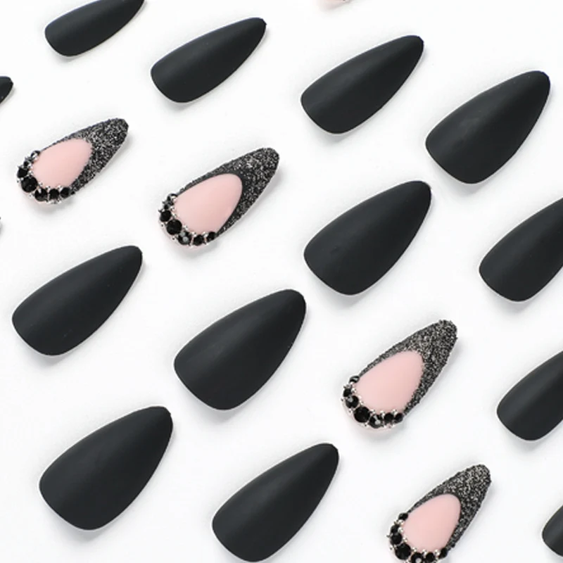 Kunstvolle Stiletto-Nägel mit elegantem Schwarz-Design und Glitzerakzenten Karnz