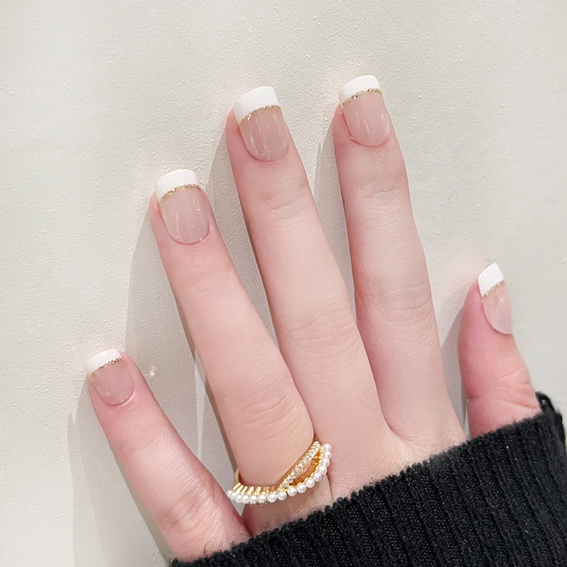 Artful nail extensions with elegant French tip and gold accents Stornfield