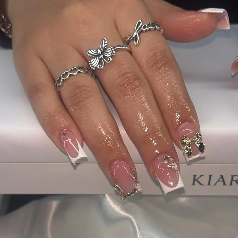 Elegant Nail Extensions with French Tips and Decorative Accents Stornfield