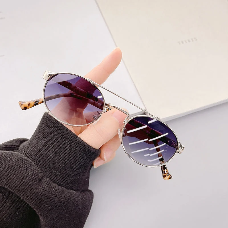 Dame moteriktig solbrille i stilfullt rundt design med gull aksenter Luvikno