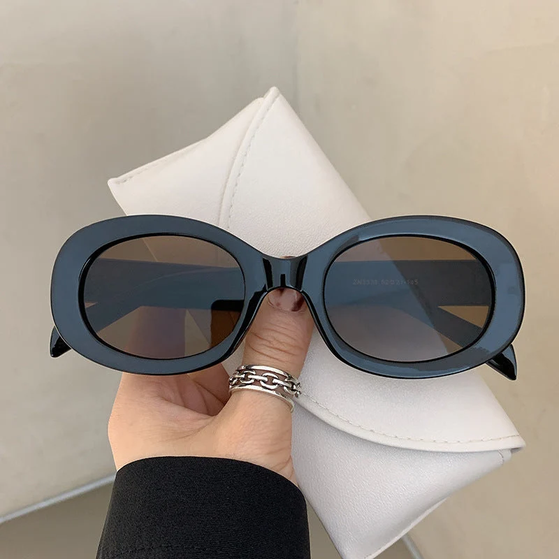 Dame moteriktig solbrille i elegant ovalt design med robust ramme Luvikno
