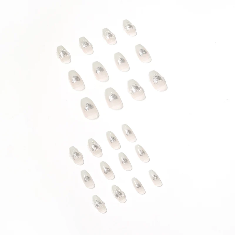 Artificial nail art with heart and rhinestone decorations Stornfield
