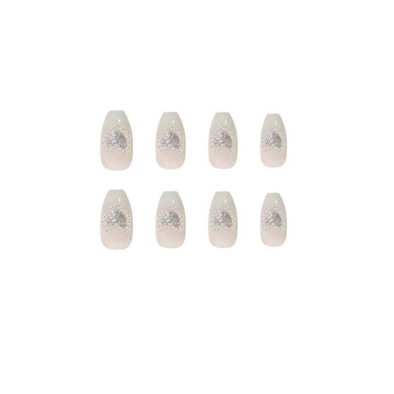 Artificial nail art with heart and rhinestone decorations Stornfield