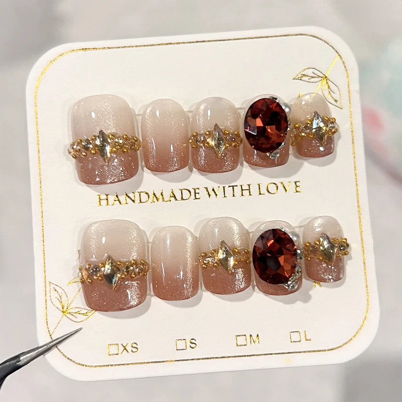 Artificial nail art with glitter and jewelry embellishments Stornfield