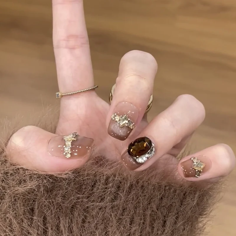 Artificial nail art with glitter and jewelry embellishments Stornfield