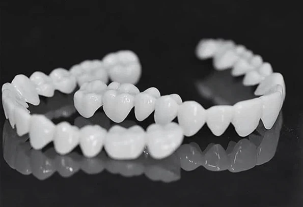 Anpassbare Zahnprothese mit Zahnlinsen