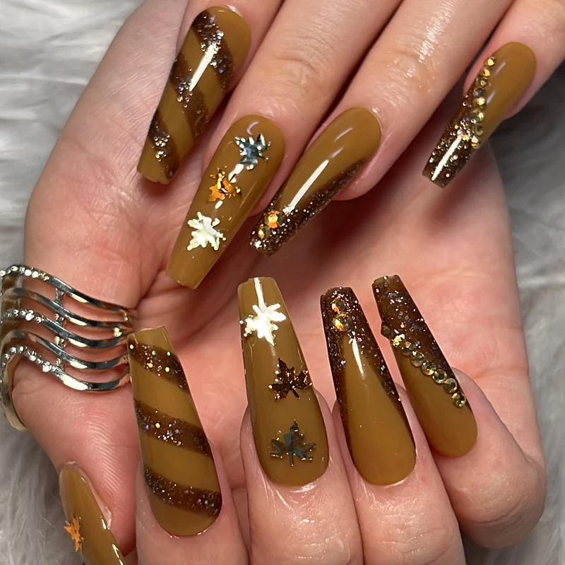 Artful Nail Art with Glitter and Leaf Design Stornfield