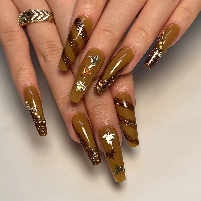 Artful Nail Art with Glitter and Leaf Design Stornfield