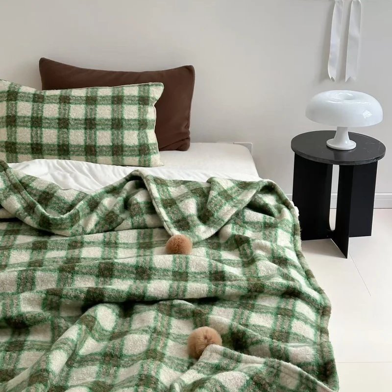 Kuscheldecke mit kariertem Muster und Bommelverzierung Karnz