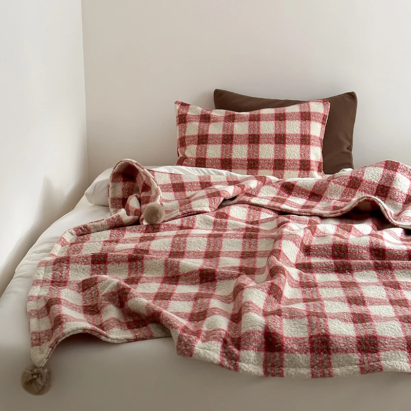 Kuscheldecke mit kariertem Muster und Bommelverzierung Karnz