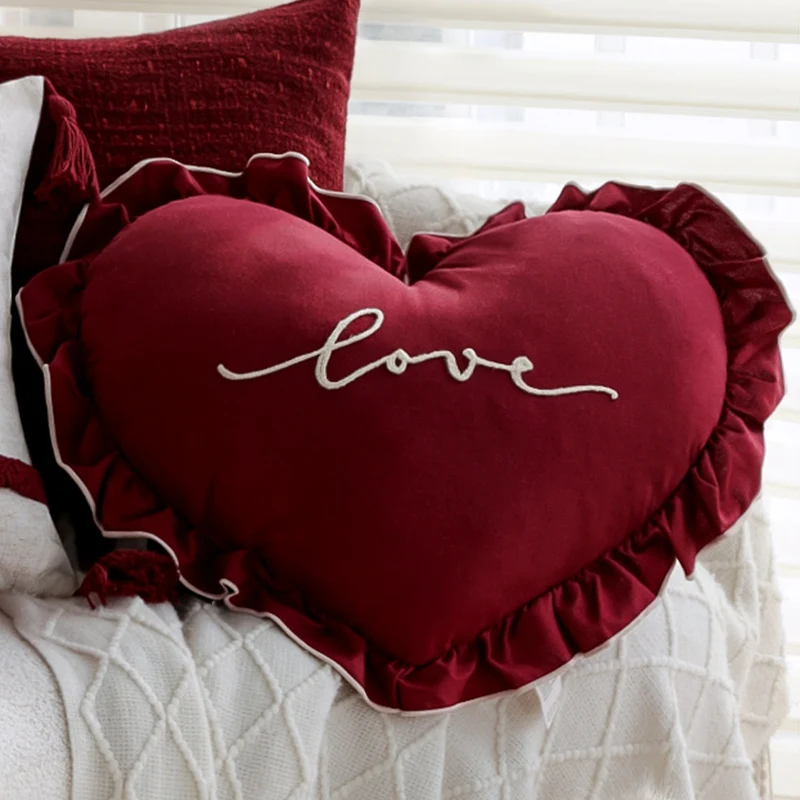 Heart-shaped decorative pillow with ruffled trim and embroidered inscription Stornfield