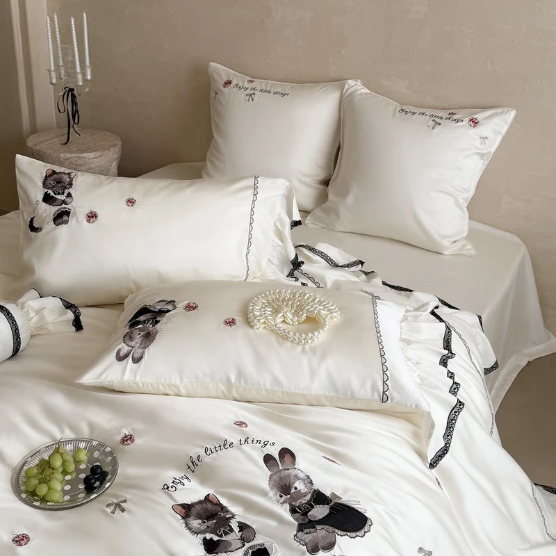 Romantic satin bed linen set with ruffled hem and embroidered animal appliqués Stornfield