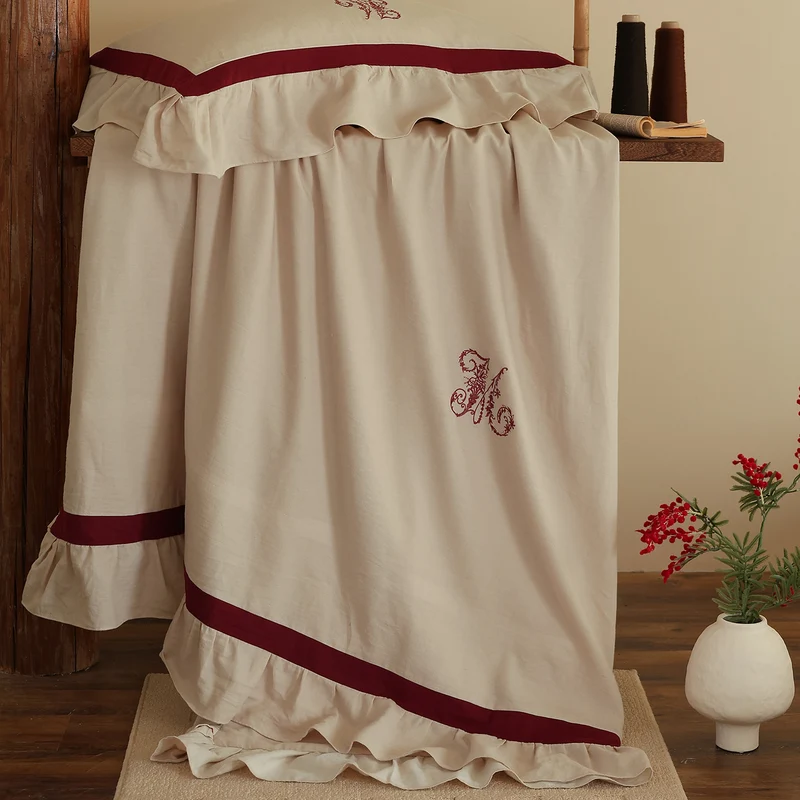 Romantic cotton-linen bedding set with ruffle, monogram embroidery, and contrasting trim Stornfield