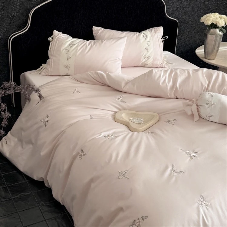 Luxurious satin bedding set with embroidered floral appliqués and bolster Stornfield
