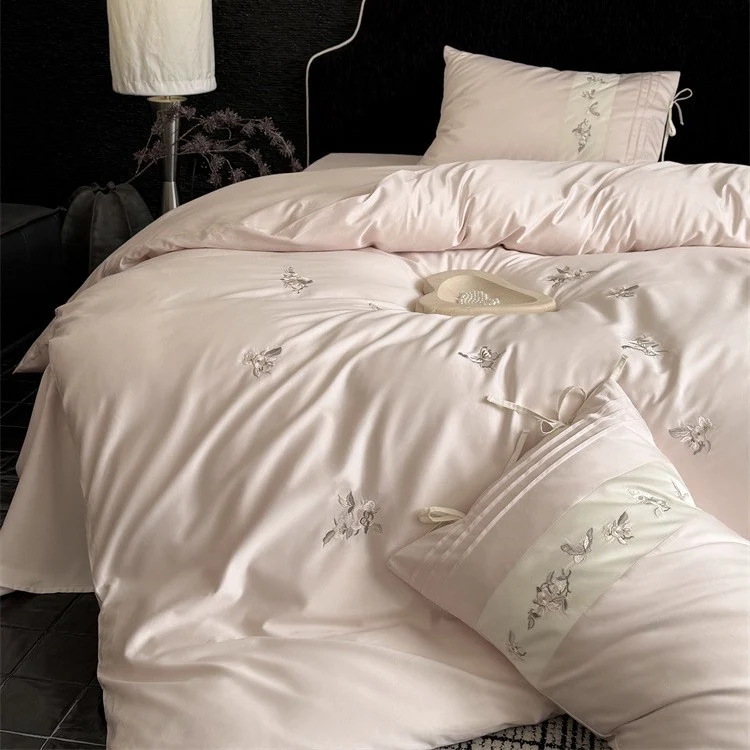 Luxurious satin bedding set with embroidered floral appliqués and bolster Stornfield