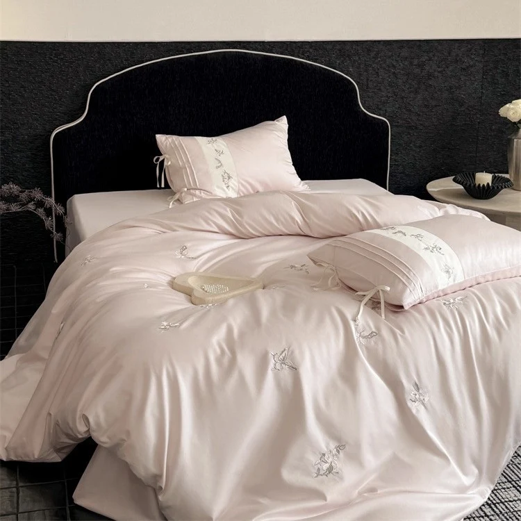 Luxurious satin bedding set with embroidered floral appliqués and bolster Stornfield