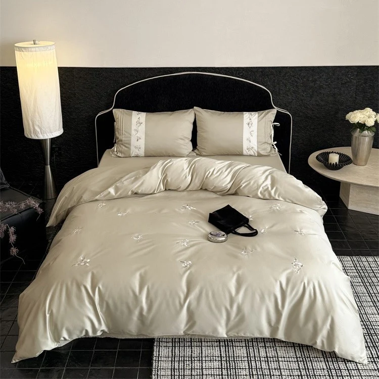 Luxurious satin bedding set with embroidered floral appliqués and bolster Stornfield