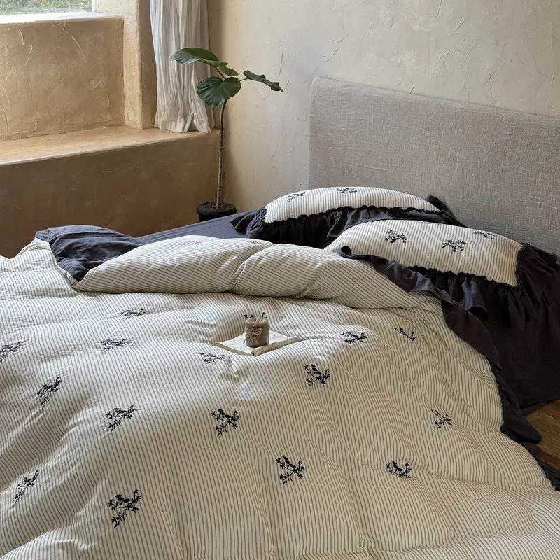 Striped bedding set with fine floral embroidery and ruffled pillowcases Stornfield