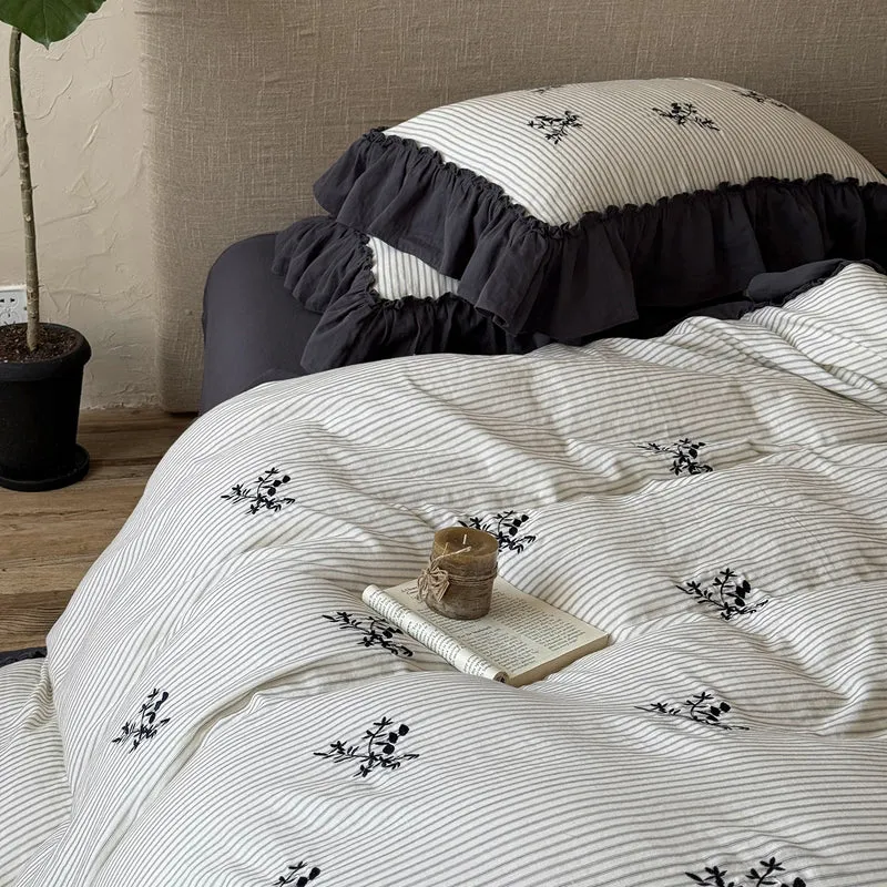 Striped bedding set with fine floral embroidery and ruffled pillowcases Stornfield
