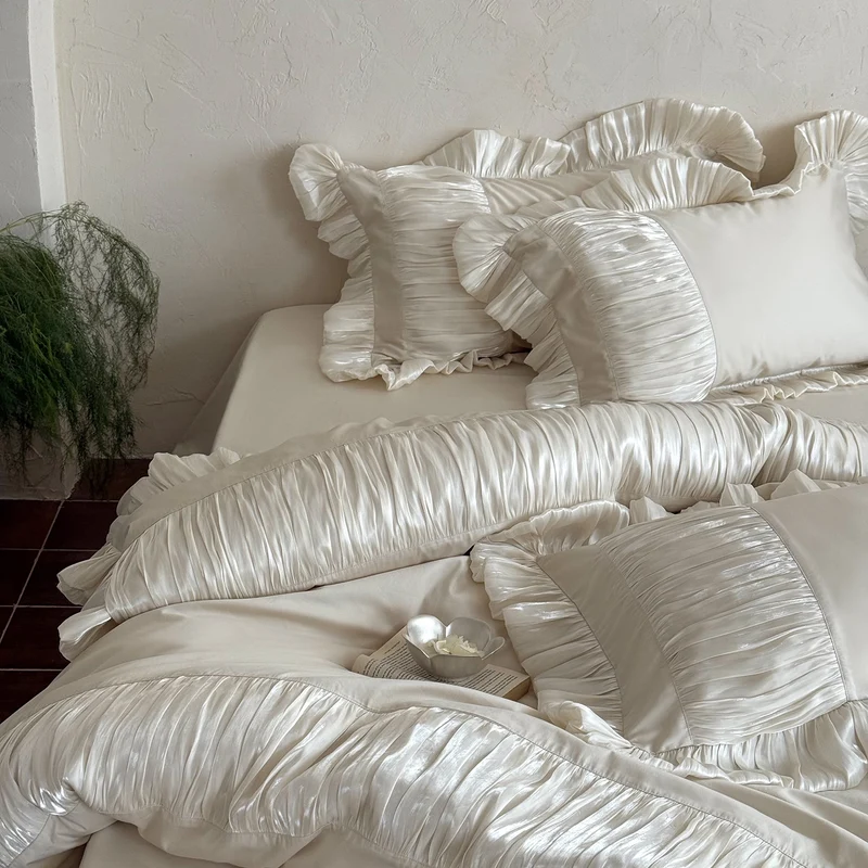 Elegant satin bed linen set with pleated inserts, ruffled edges and decorative cushions Stornfield