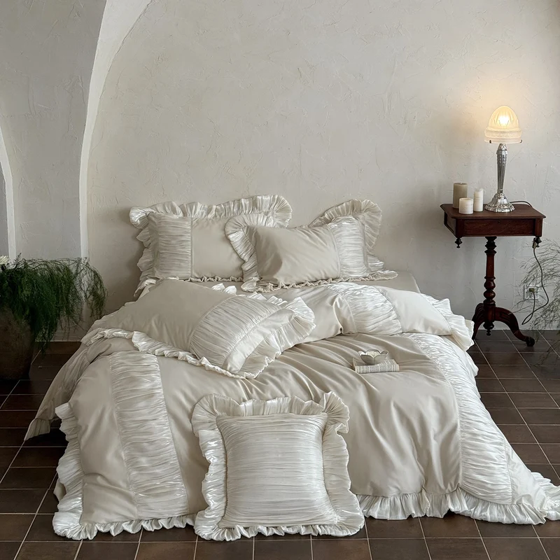 Elegant satin bed linen set with pleated inserts, ruffled edges and decorative cushions Stornfield