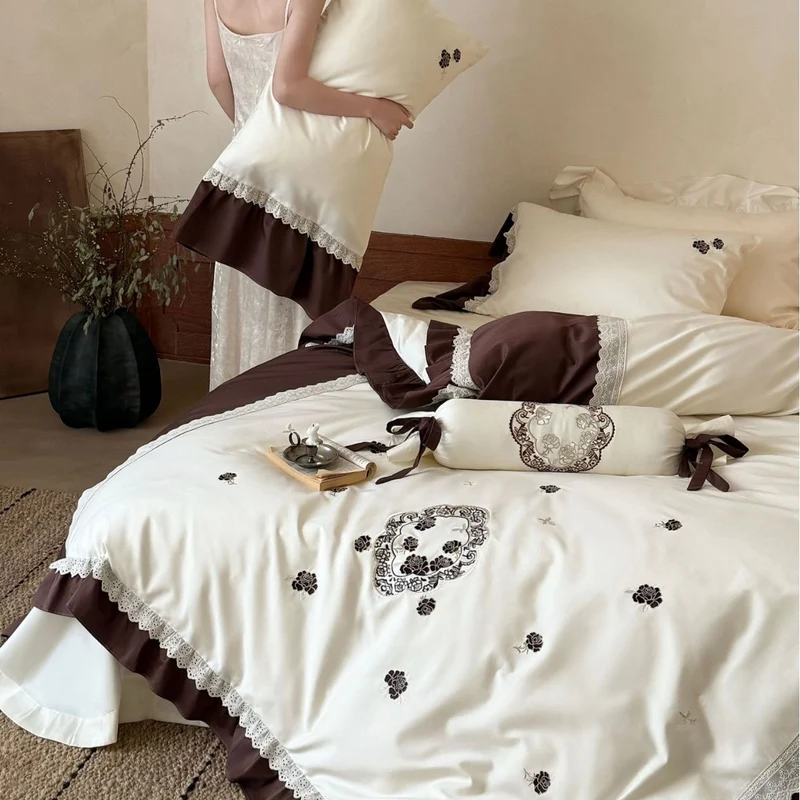 Luxurious embroidered bedding set with ruffle and decorative roll Stornfield
