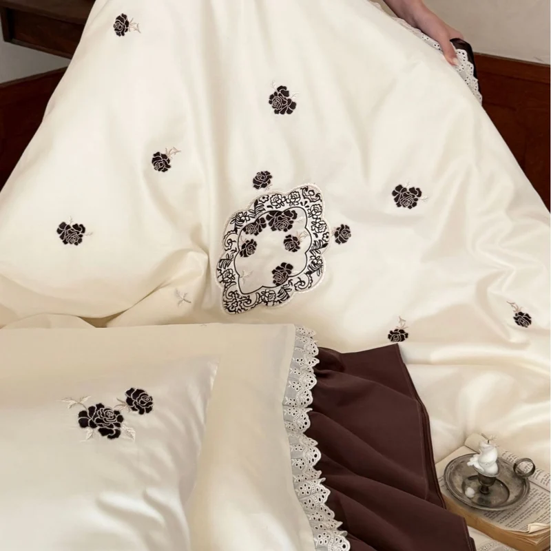 Luxurious embroidered bedding set with ruffle and decorative roll Stornfield
