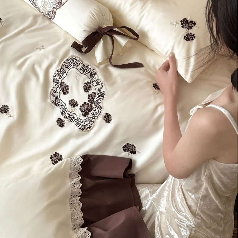 Luxurious embroidered bedding set with ruffle and decorative roll Stornfield