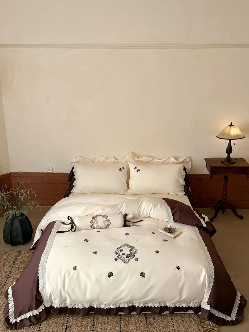 Luxurious embroidered bedding set with ruffle and decorative roll Stornfield