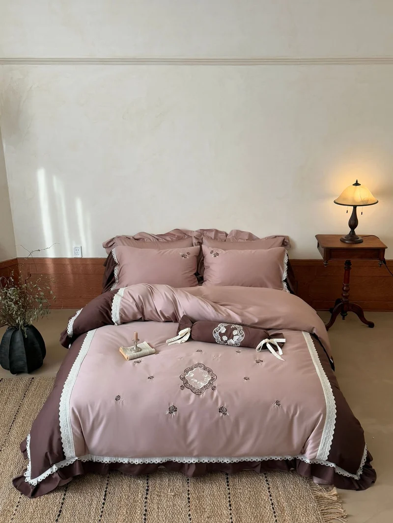 Luxurious embroidered bedding set with ruffle and decorative roll Stornfield