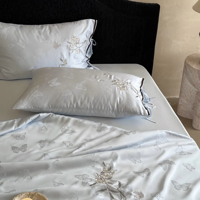 Light jacquard satin bed linen set with embroidered butterfly motif and decorative roll Stornfield