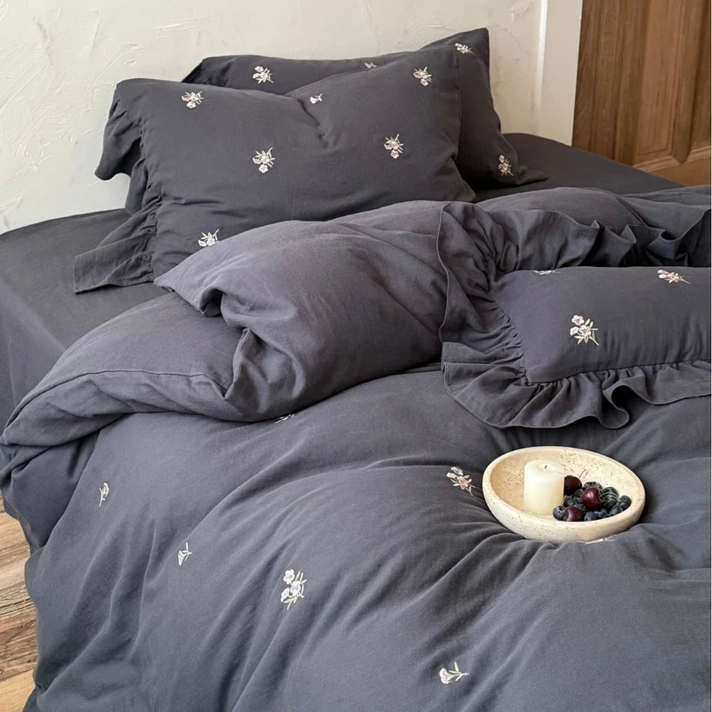 Cotton satin bedding set with delicate embroidered flowers, ruffled decorative pillow, and hotel closure Stornfield
