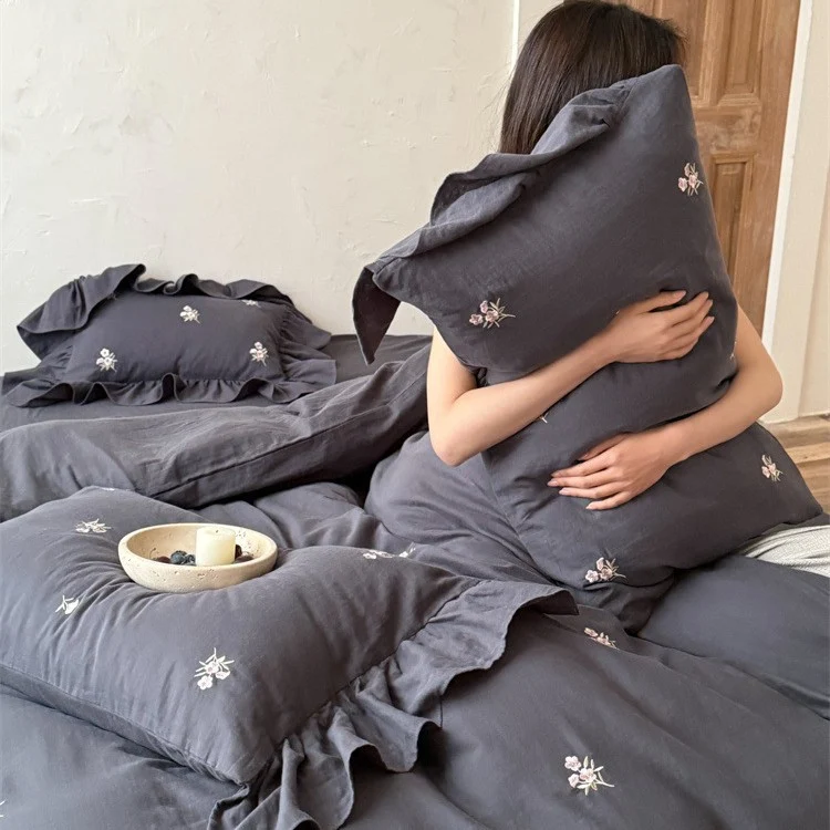Cotton satin bedding set with delicate embroidered flowers, ruffled decorative pillow, and hotel closure Stornfield