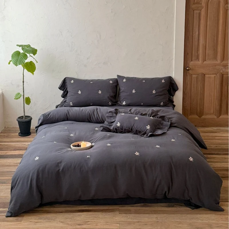 Cotton satin bedding set with delicate embroidered flowers, ruffled decorative pillow, and hotel closure Stornfield