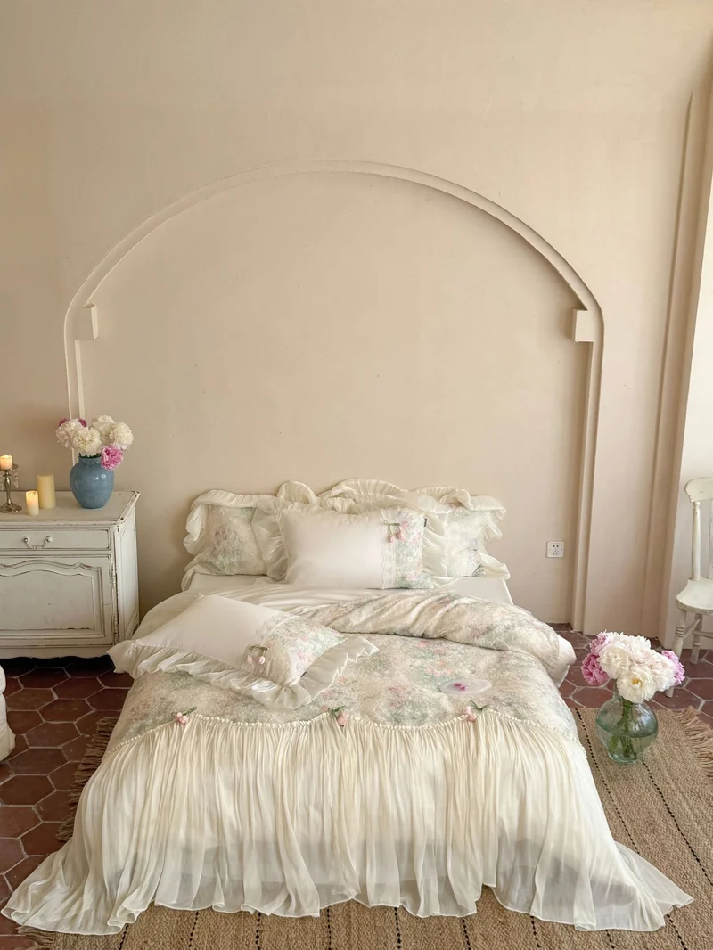 Romantic bedding set with ruffled frill, embroidered decorative pillows, and flowing pleated bedspread Stornfield