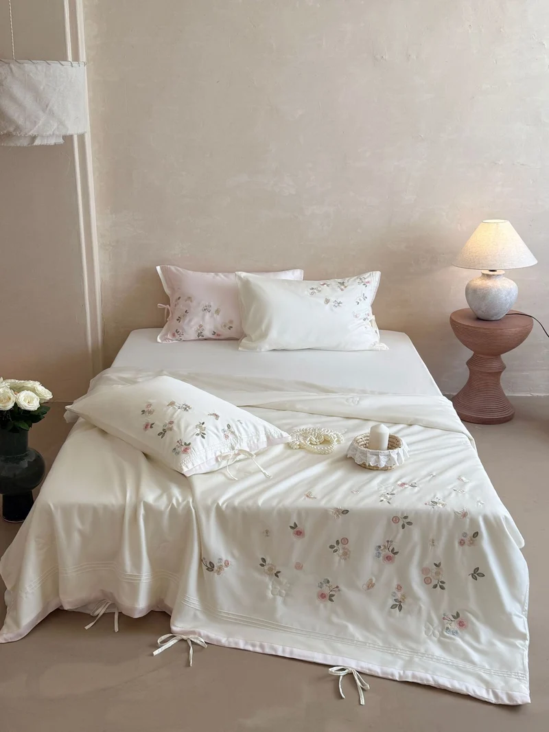 Luxurious satin bedding set with delicate floral embroidery and ribbon closure Stornfield