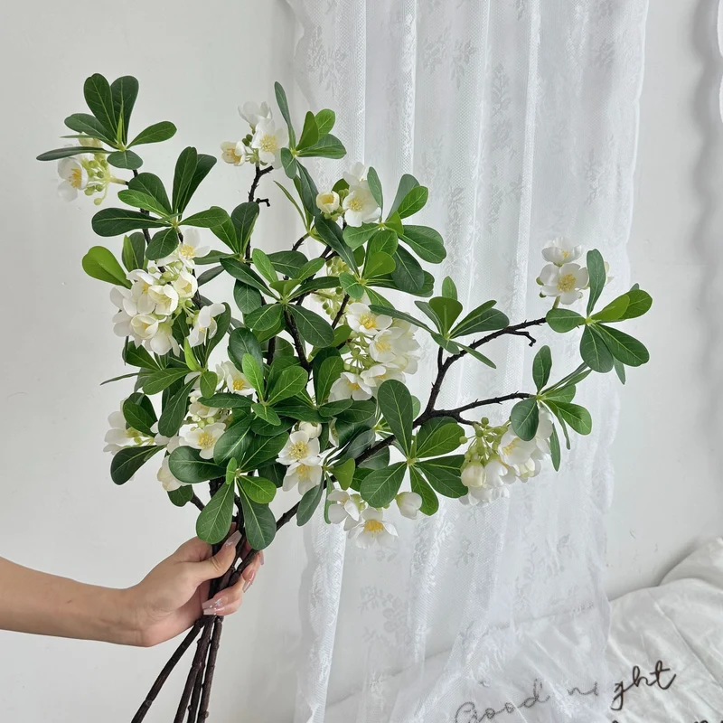 Artificial flower branch with fine pink flowers and vibrant leaves