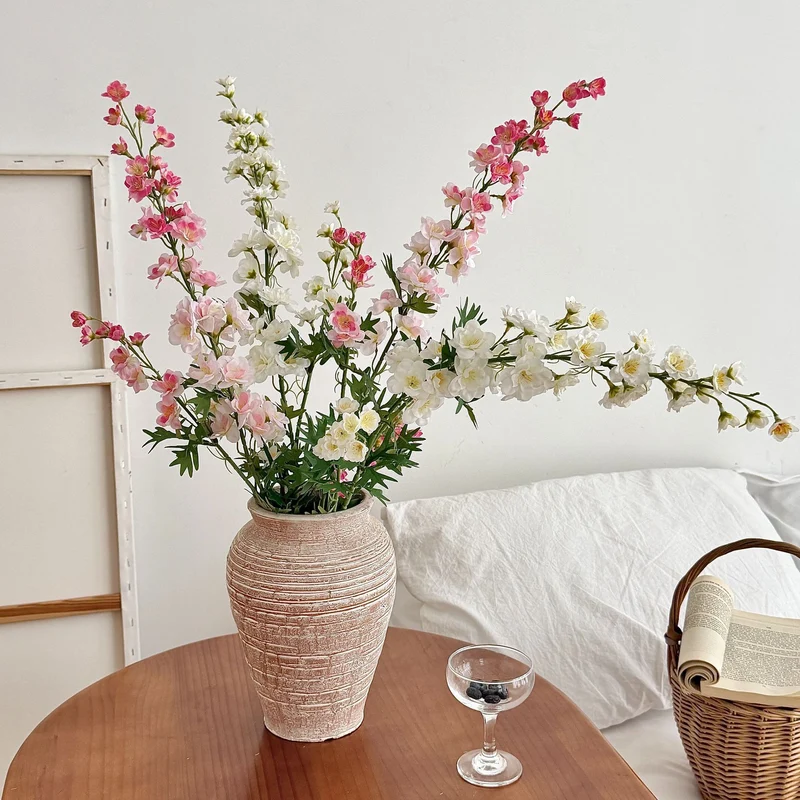 Artificial flower branch with intricately detailed red flowers