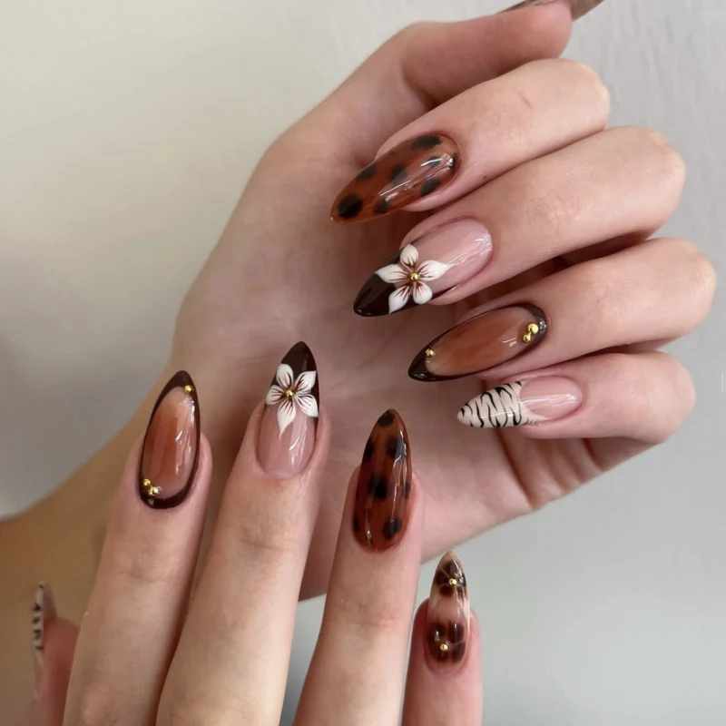 Artistic stiletto nails with elegant floral designs and glitter accents Stornfield