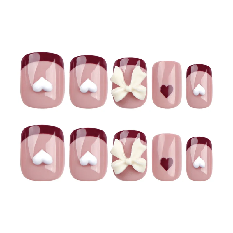 Kunstvolle Nagelkunst mit Herz- und Schleifenmotiven Karnz