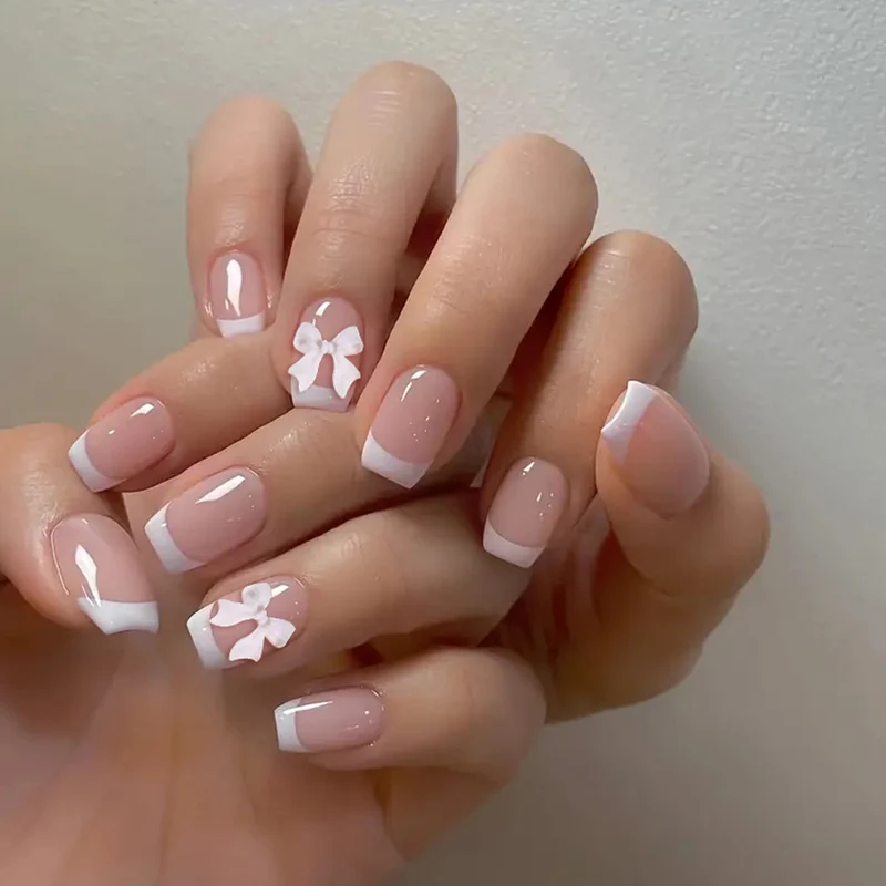 Elegant French Tip Nail Art with Bow Embellishments Stornfield