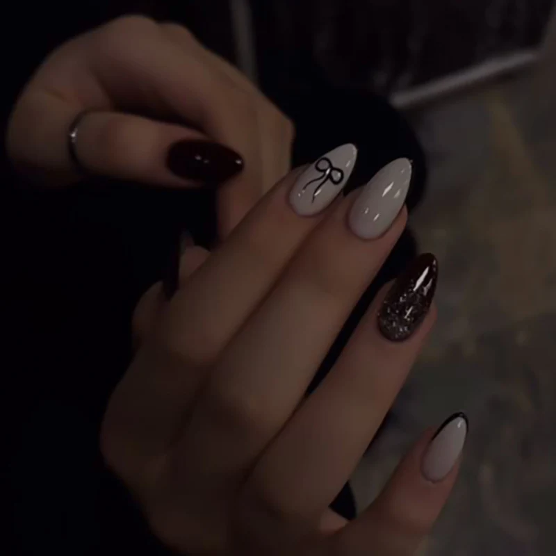 Artful nail art with elegant bow pattern and glitter accents Stornfield