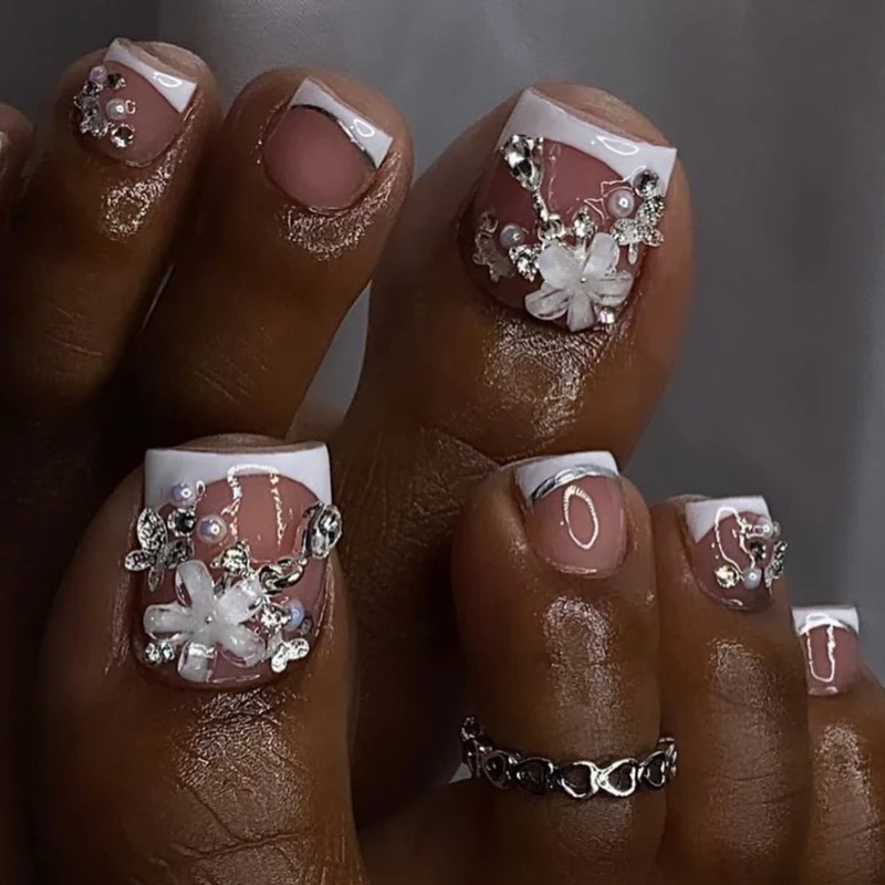 Artful toenail design with elegant flower and glitter accents Stornfield