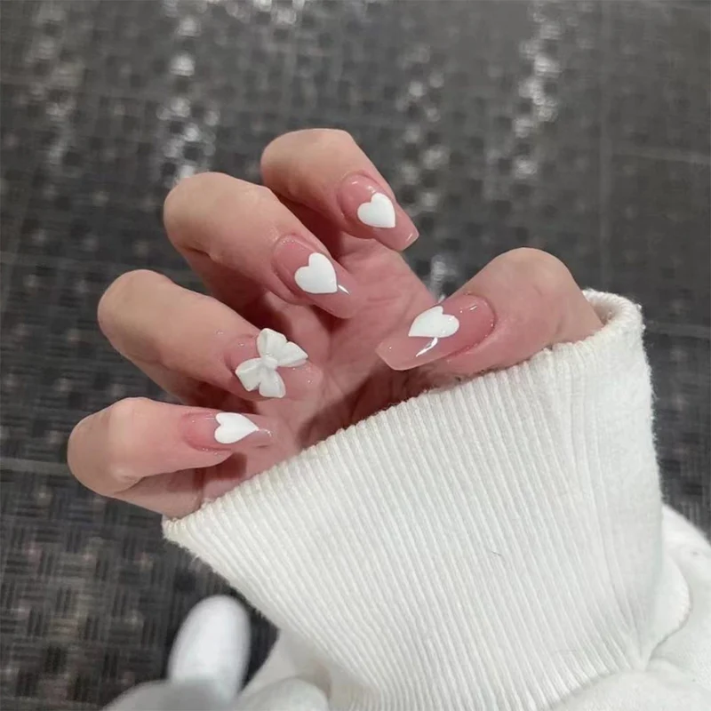 Artistic acrylic nails with heart and bow motifs Stornfield