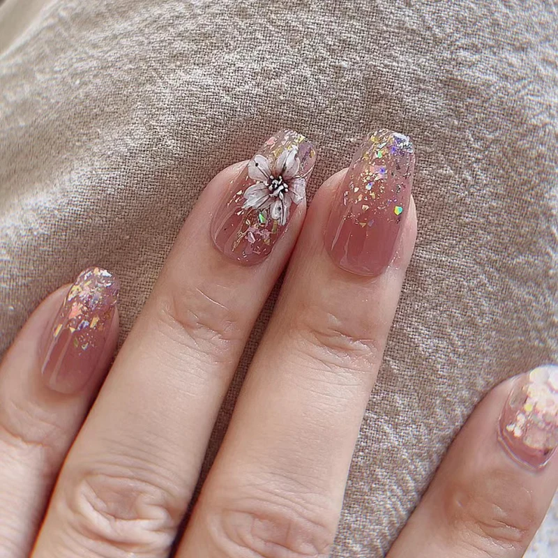 Artificial nail extensions with floral design and glitter accents Stornfield
