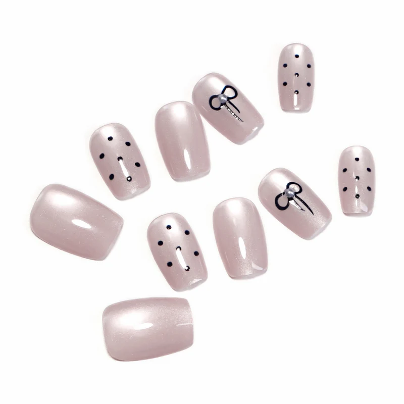 Artificial nail extensions with decorative bows and dots Stornfield