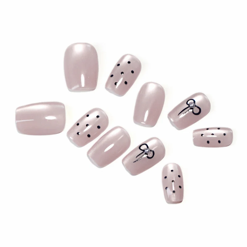 Artificial nail extensions with decorative bows and dots Stornfield