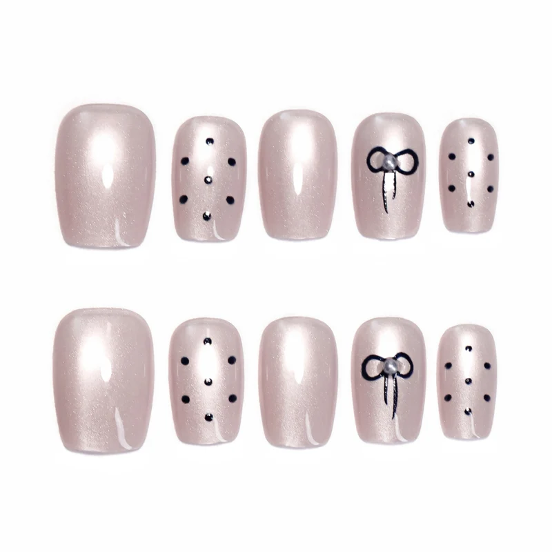Artificial nail extensions with decorative bows and dots Stornfield