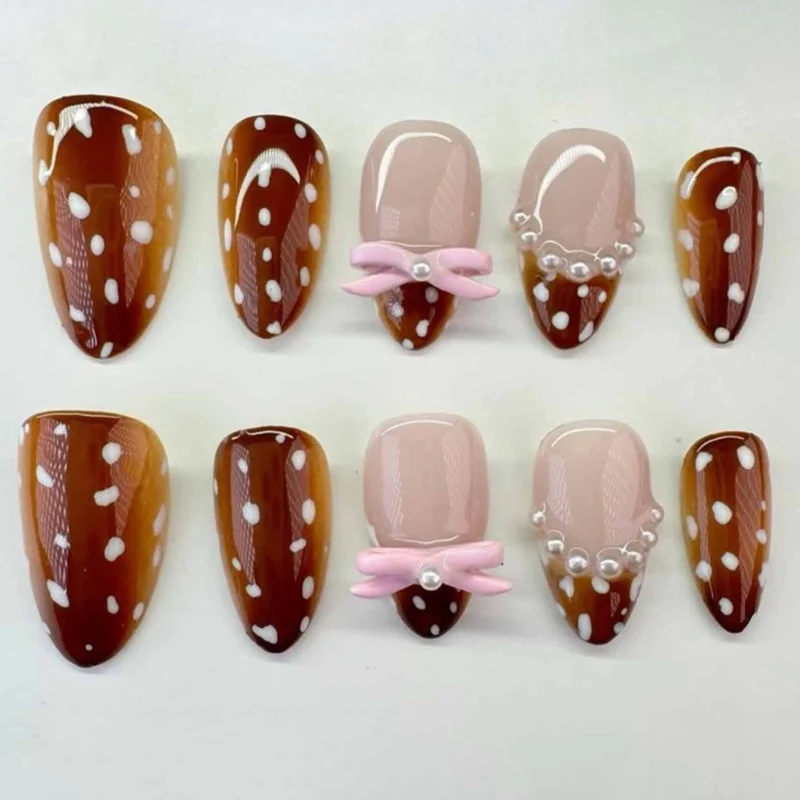 Artificial nail art with dot pattern and bow accents Stornfield
