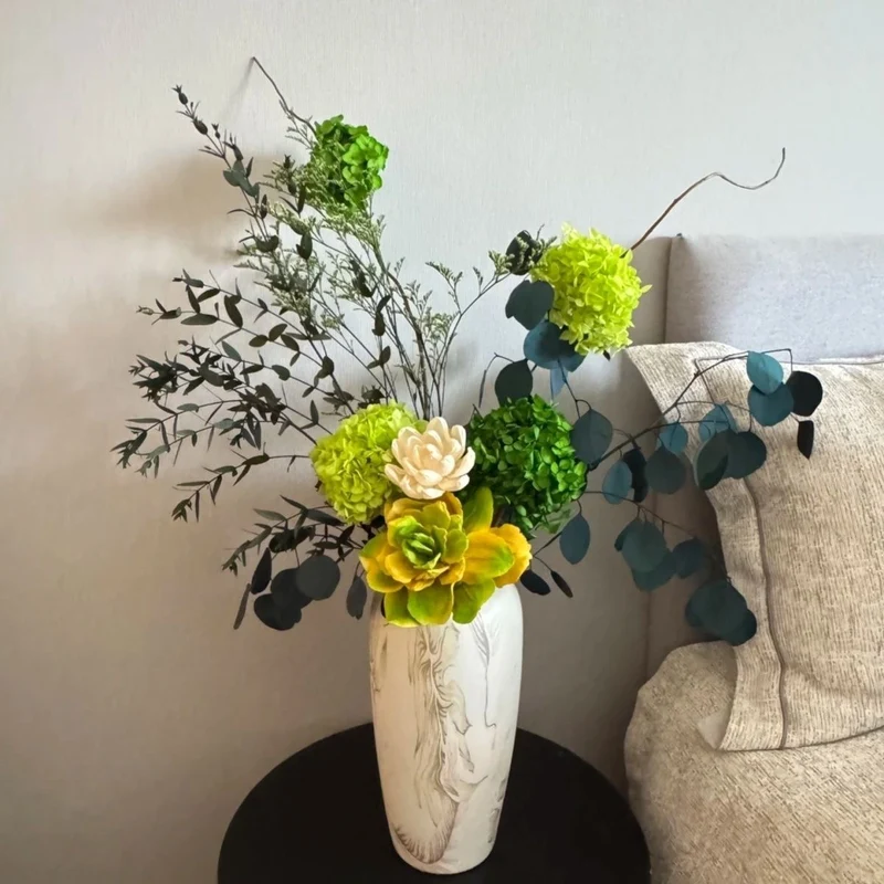Lebensechte Sukkulente und Blumenarrangement